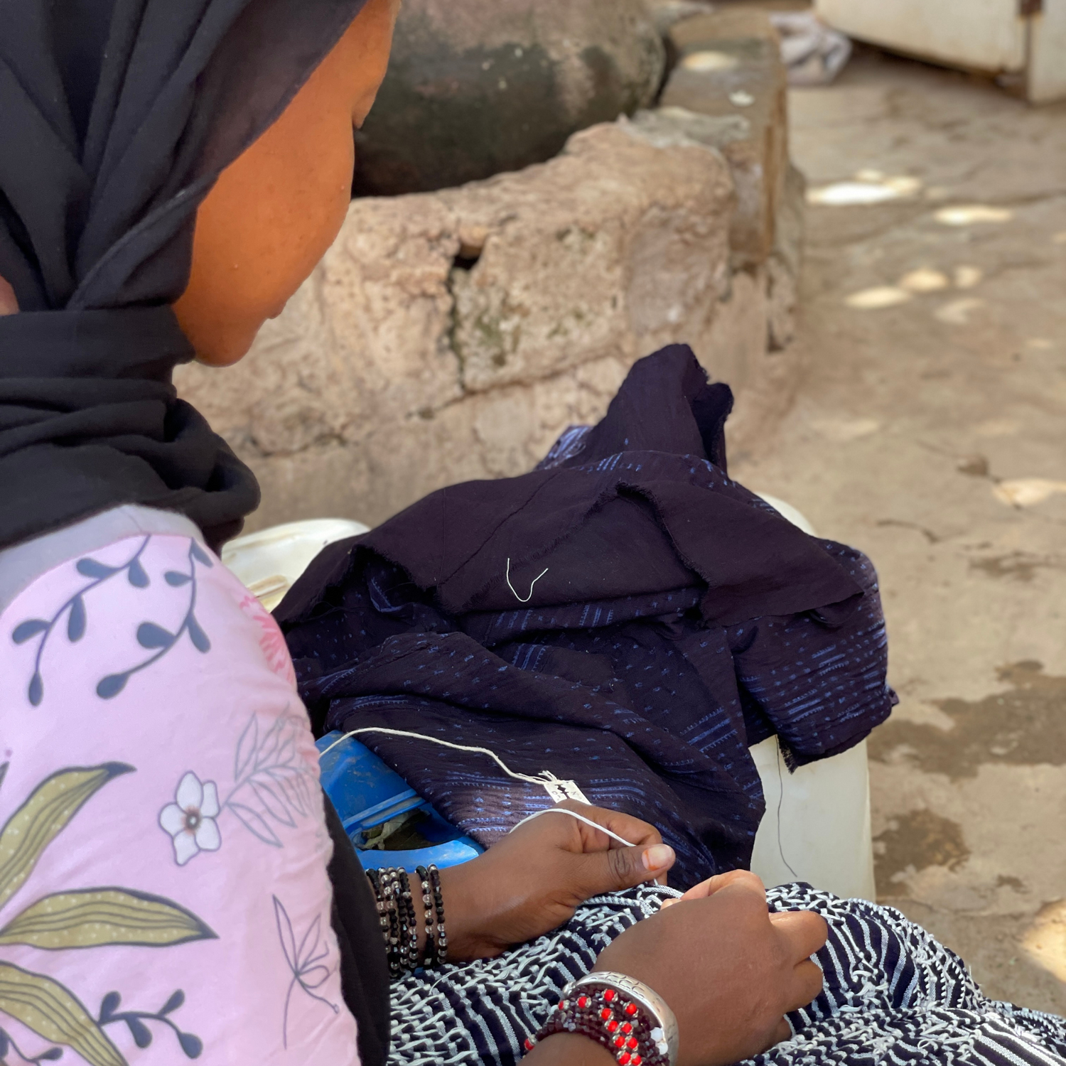 une femme entrain de réaliser des réserves sur un tissu 